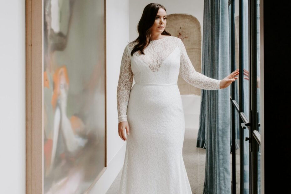 woman in white dress standing beside glass window
